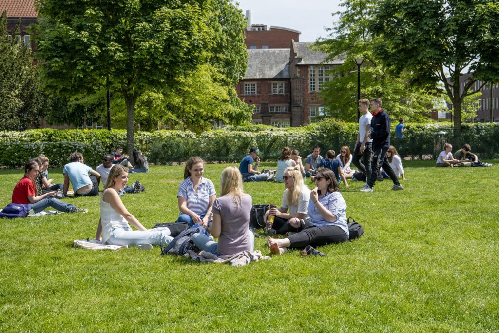 students sitting on an open field
