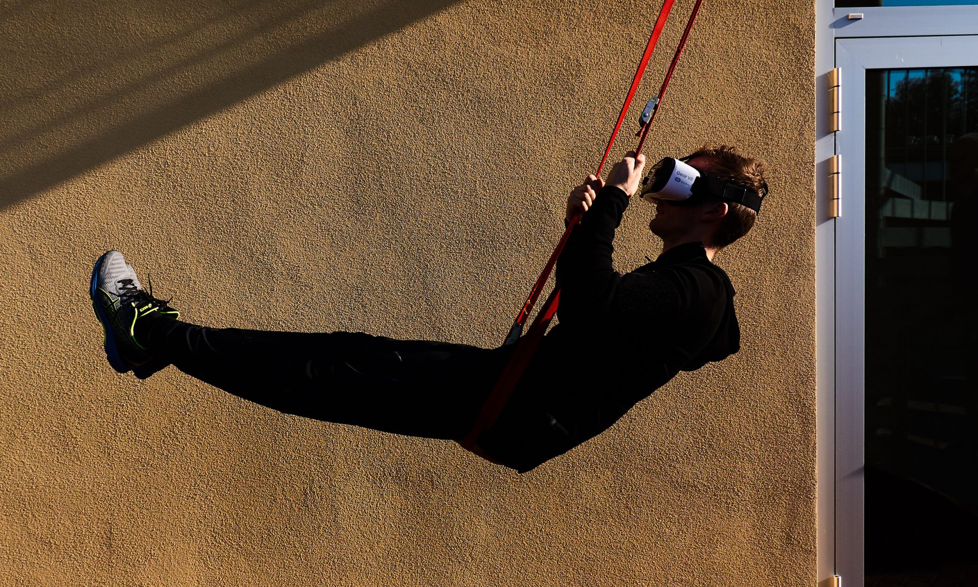 A person on a swing wearing a virtual reality headset