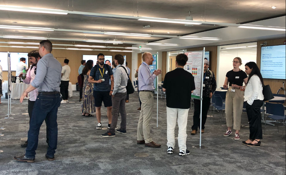 Staff discussing research posters at a C-FLEET event